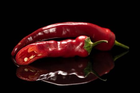 Group of one whole one half of fresh hot pepper isolated on black glassの写真素材