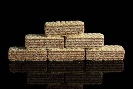 Group of six whole crispy beige hazelnut wafer cookie isolated on black glassの写真素材