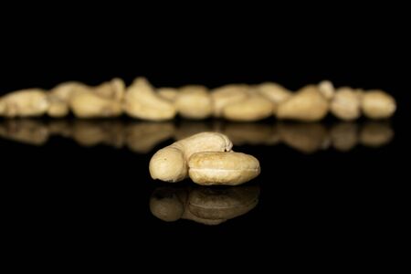 Lot of whole brown nut cashew two in focus isolated on black glass