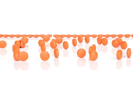 Lot of whole arranged orange tablet pharmacy isolated on white backgroundの写真素材