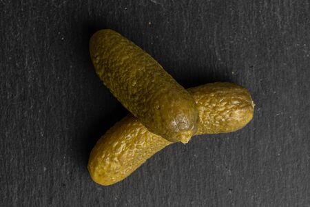 Group of two whole sour green pickle flatlay on grey stone