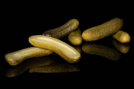Group of four whole two halves of sour green pickle isolated on black glassの写真素材