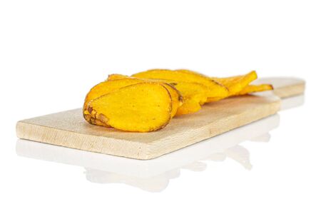 Lot of whole dry vegetable chip of gourd on small wooden cutting board isolated on white backgroundの写真素材