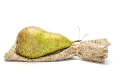 One whole fresh green pear conference with jute bag isolated on white backgroundの写真素材