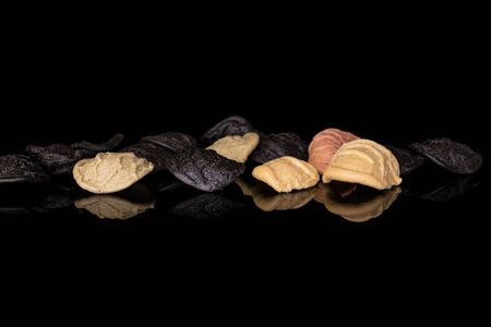 Lot of whole colorful pasta orecchiette in row isolated on black glassの写真素材