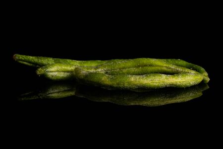 Group of three whole dry vegetable chip of green bean isolated on black glass