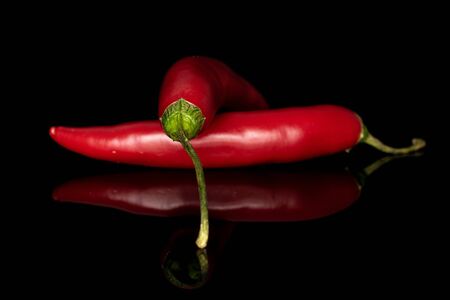 Group of two whole hot red chili cayenne isolated on black glassの写真素材