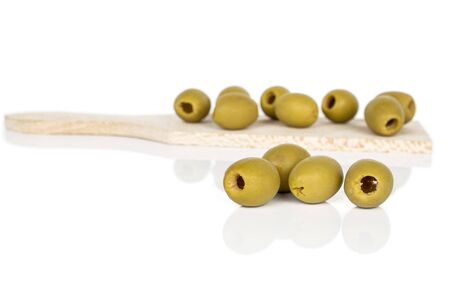 Group of twelve whole marinated green olive on wooden cutting board isolated on white backgroundの写真素材