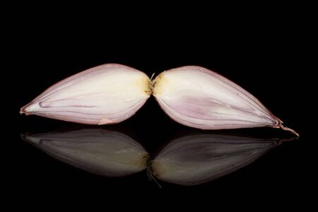 Group of two halves of fresh brown shallot isolated on black glass