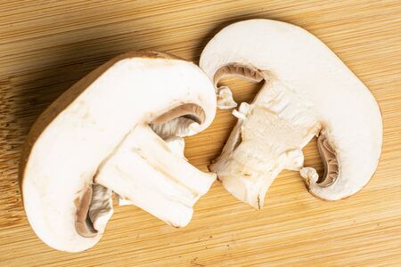Group of one half one slice of fresh brown mushroom champignon flatlay on light woodの写真素材