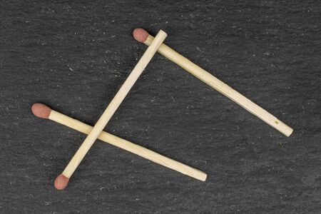 Group of three whole brown safety match flatlay on grey stone