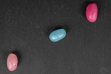 Group of three whole jelly bean candy flatlay on grey stoneの写真素材