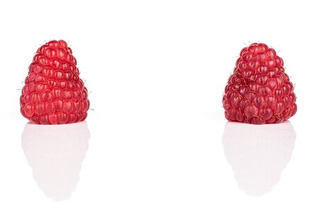 Group of two whole fresh red raspberry isolated on white background