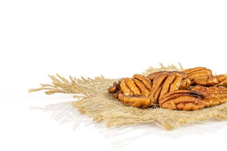 Lot of whole dry brown pecan nut on natural sackcloth isolated on white background