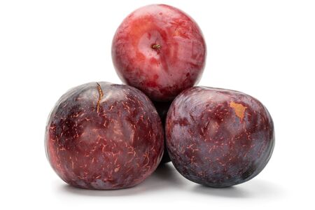 Group of three whole juicy fresh red plum isolated on white backgroundの写真素材