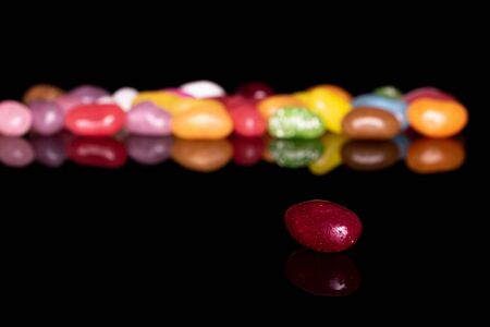 Lot of whole jelly bean candy isolated on black glassの写真素材