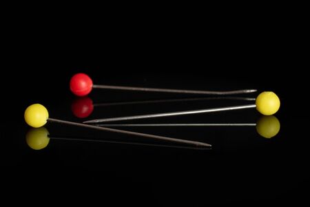 Group of three whole haberdashery item needles isolated on black glass