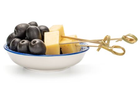 Lot of whole canned black olive on porcelain saucer with bamboo skewer and piece of cheese isolated on white backgroundの写真素材