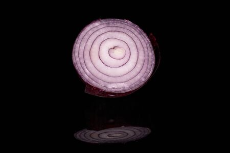 One half of tasty onion red isolated on black glassの写真素材