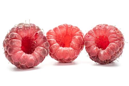 Group of three whole fresh crimson raspberry isolated on white background