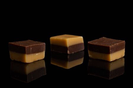 Group of three whole sweet brown caramel chocolate candy isolated on black glassの素材 [FY310132860437]