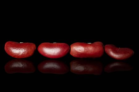 Group of four whole fresh red kidney beans isolated on black glassの写真素材