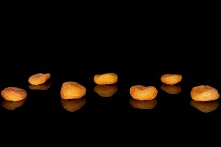 Group of seven whole dried orange apricot isolated on black glassの写真素材