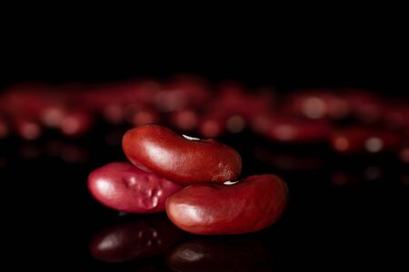 Lot of whole dried fresh red kidney beans isolated on black glassの写真素材