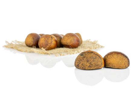 Lot of whole sweet brown chestnut on natural sackcloth isolated on white backgroundの写真素材