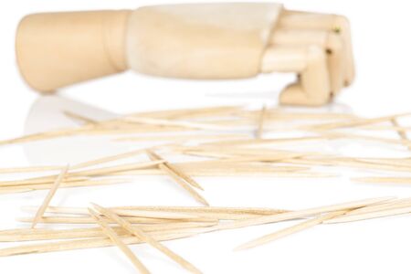 Lot of whole light wooden brown toothpick with wooden hand isolated on white backgroundの写真素材