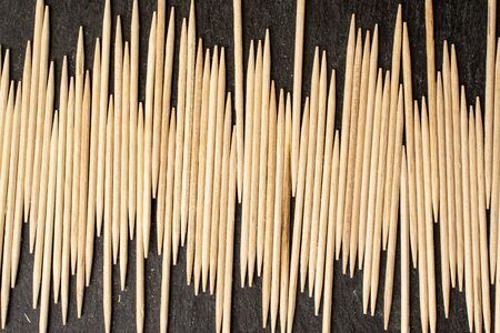 Lot of whole wooden brown toothpick flatlay on grey stoneの写真素材
