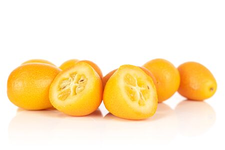 Group of three whole two halves of tasty orange kumquat isolated on white backgroundの写真素材
