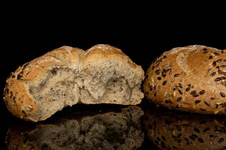 Group of one whole one half of sesame kaiser roll isolated on black glass
