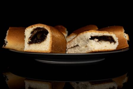 Group of six whole sweet czech bun on gray ceramic plate isolated on black glass