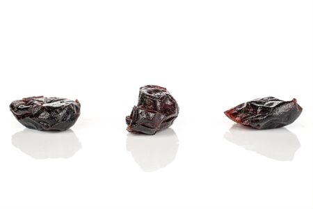 Group of three whole dried cowberry																 isolated on white background