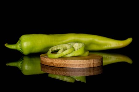 Group of one whole three slices of hot green pepper banana on round bamboo coaster isolated on black glassの写真素材