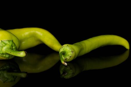 Group of two whole hot green pepper banana isolated on black glassの写真素材