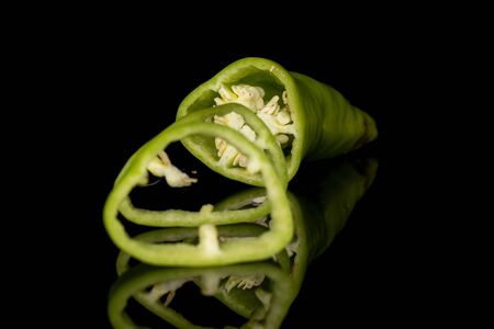 Group of one half two slices of hot green pepper banana isolated on black glass