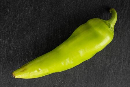 One whole hot green pepper banana flatlay on grey stoneの写真素材