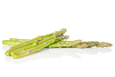 Group of seven whole healthy green asparagus isolated on white backgroundの写真素材