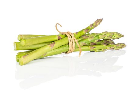 Lot of whole healthy green asparagus with straw rope isolated on white backgroundの写真素材