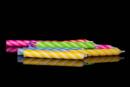 Lot of whole birthday cake candle isolated on black glassの写真素材