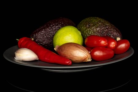 Lot of whole ingredient guacamole on gray ceramic plate isolated on black glassの写真素材