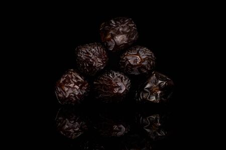 Group of six whole dried brown date fruit isolated on black glassの写真素材