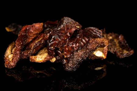 Lot of whole dried red tomato piece isolated on black glassの写真素材
