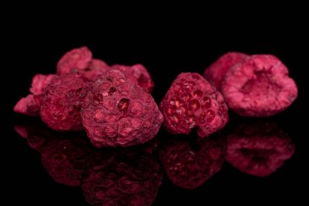 Lot of whole dried raspberry isolated on black glassの写真素材