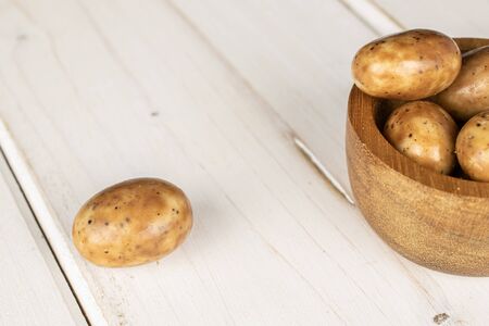 Group of five whole tiramisu brown almond nut in bamboo bowl on white woodの写真素材