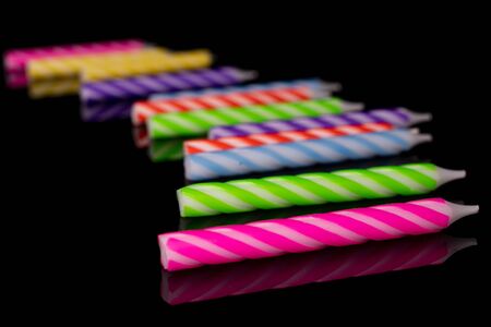 Group of twelve whole birthday cake candle isolated on black glassの写真素材