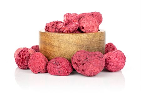 Lot of whole dried raspberry in bamboo bowl isolated on white background