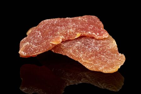 Group of two whole dried orange papaya piece isolated on black glassの写真素材